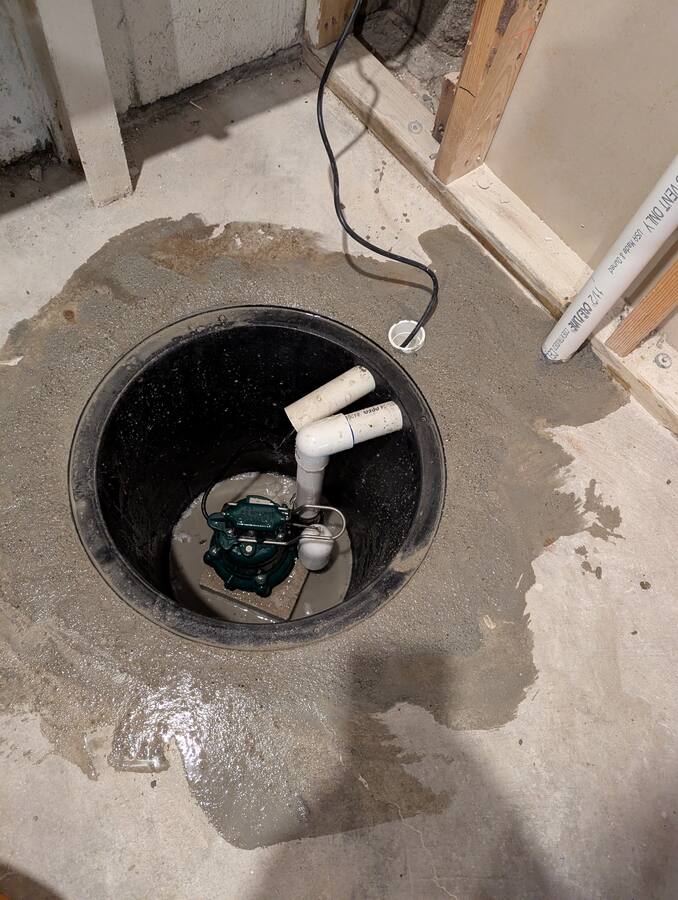 Open sump basin with pump, float, and discharge piping